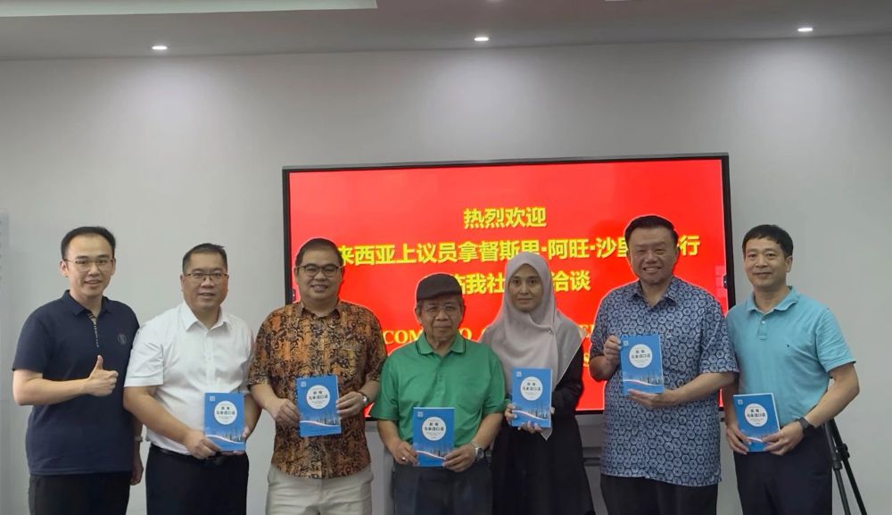 广西教育出版社总编辑陆思成向马方参会人员赠送广西教育出版社图书《新编马来语口语》（中文版）。